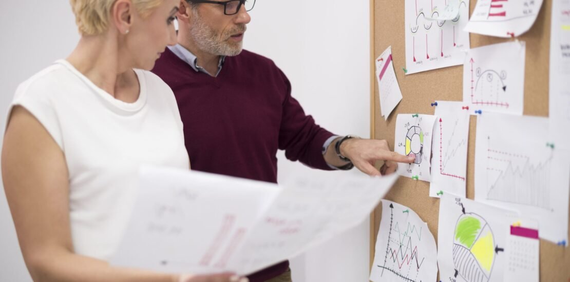 man-pointing-important-papers-cork-board